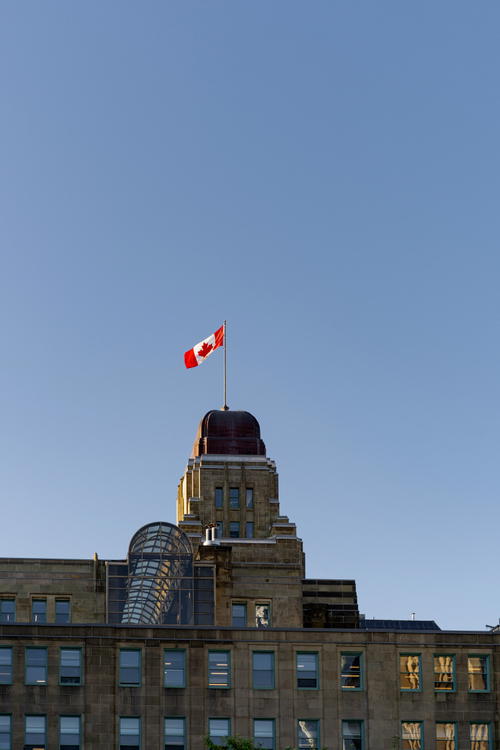 A canadian flag flying on top of a building