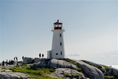 A view of Peggy's Cove Lighthouse with rocks in the foreground.
