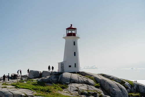 A view of Peggy's Cove Lighthouse with rocks in the foreground.