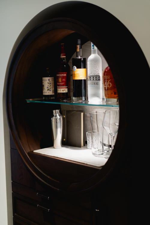A round cabinet with liquor bottles in it at Muir Hotel in Halifax, Canada.