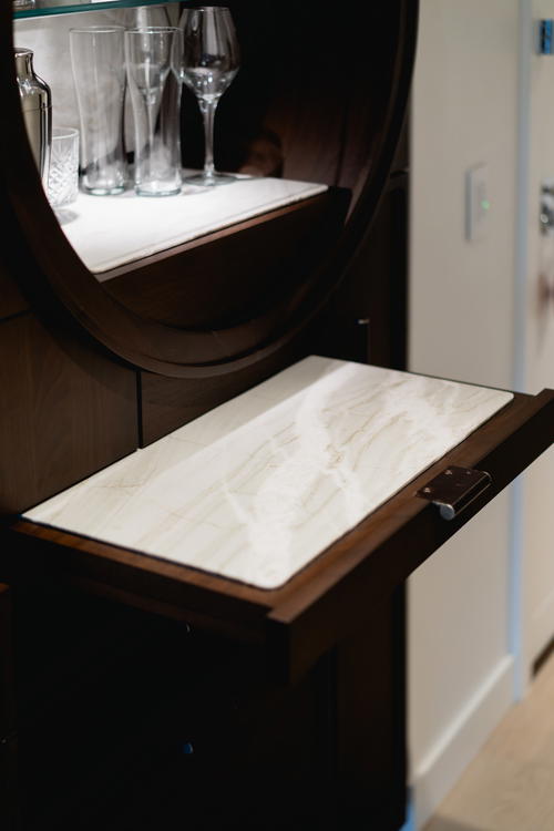 A wooden cabinet with a glass door and a drawer located at Muir Hotel in Halifax, Canada.