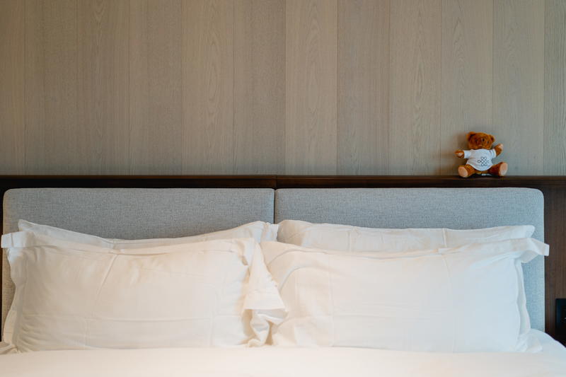 A Halifax teddy bear sits on top of a bed.