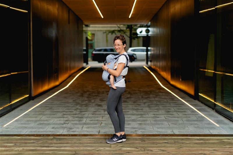 A woman standing in a hallway with a baby in a carrier in Halifax, Canada.