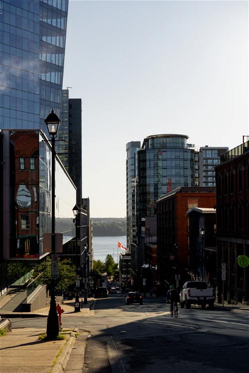 A city street with tall buildings and a large body of water in Halifax, Canada.