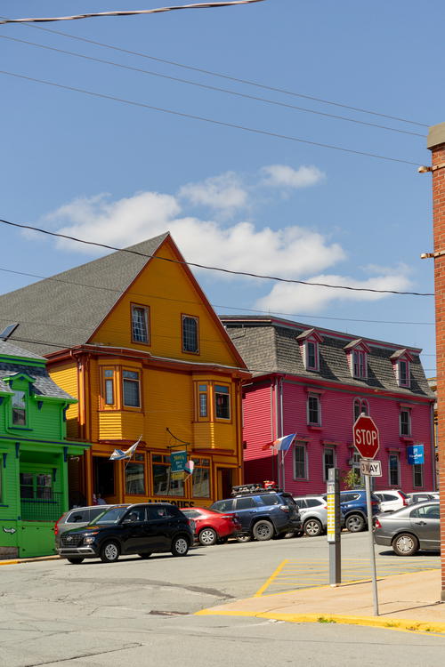 A stop sign in front of a row of colorful buildings
