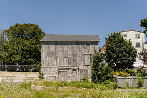 An old wooden building sitting in the middle of a field