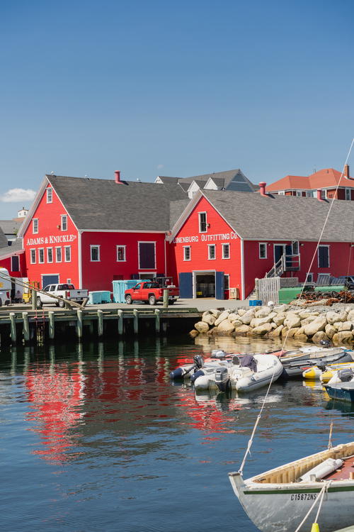 A harbor with boats and a red building in the background