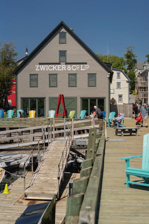 A wooden dock with benches and a building in the background