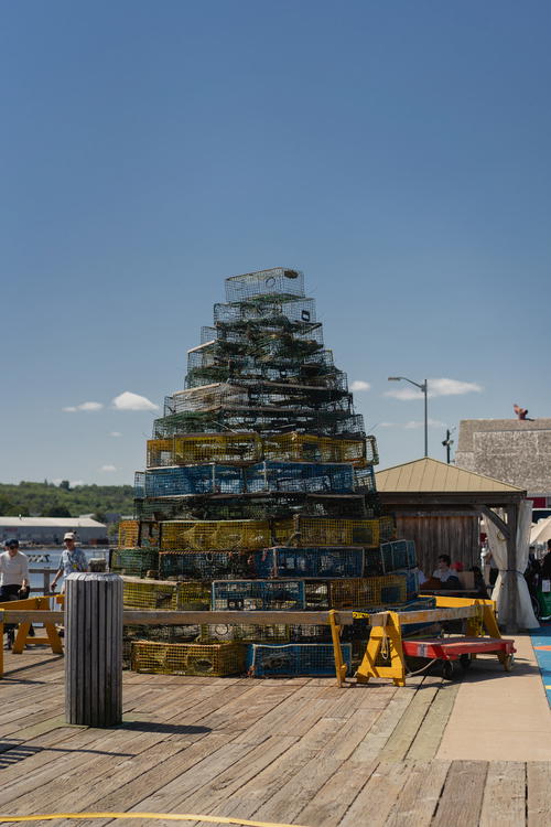 A large stack of crates sitting on top of a wooden pier