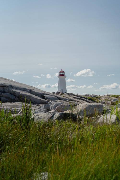 A light house sitting on top of a rocky hill