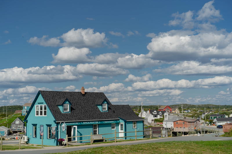 A blue house sitting on the side of a road