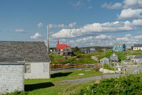 A small village with a few houses on the other side of the road