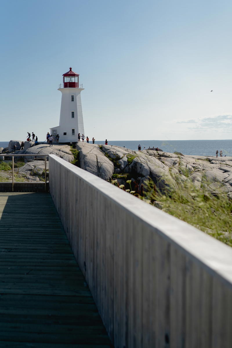 A walkway leading to a light house on a rocky shore