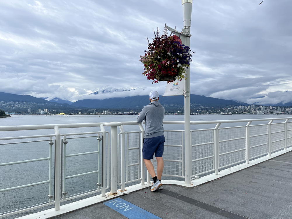 A man standing on a ferry looking at the water