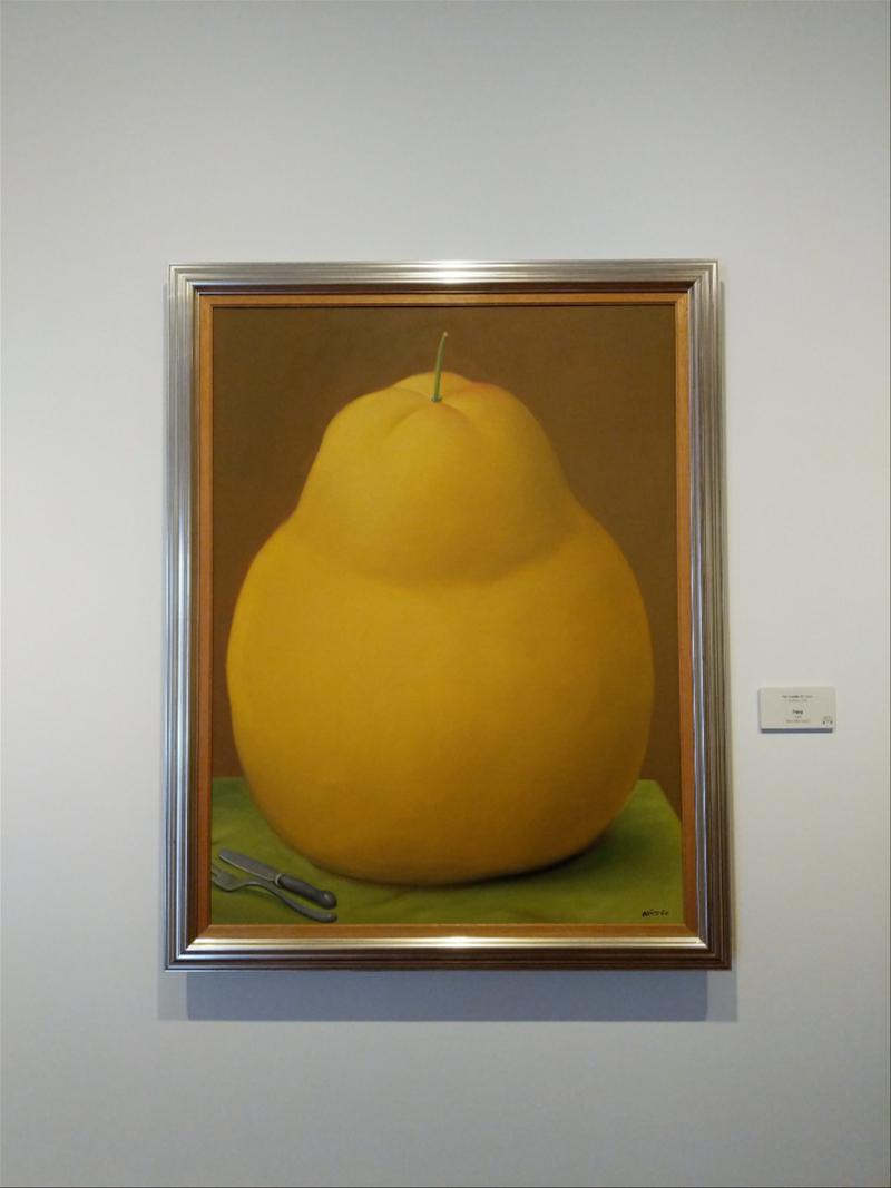 A painting of a yellow pear hanging on a wall.