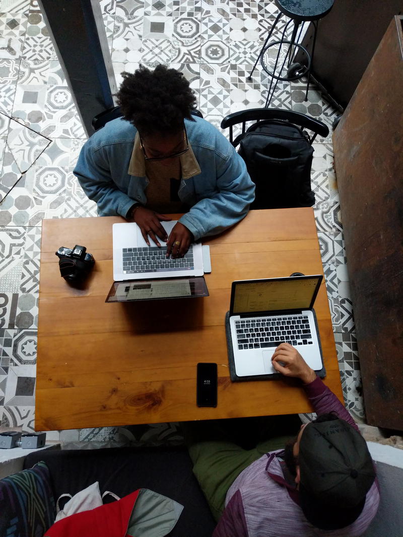 Two men working on laptops at a table.