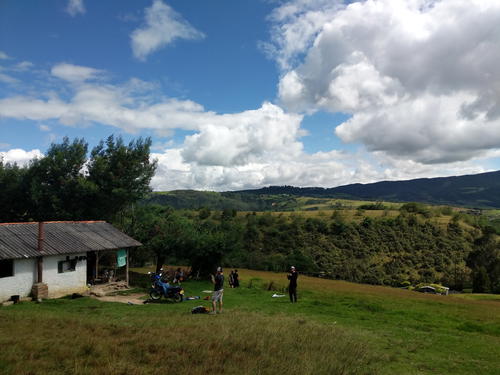 A small house in the middle of a grassy field.