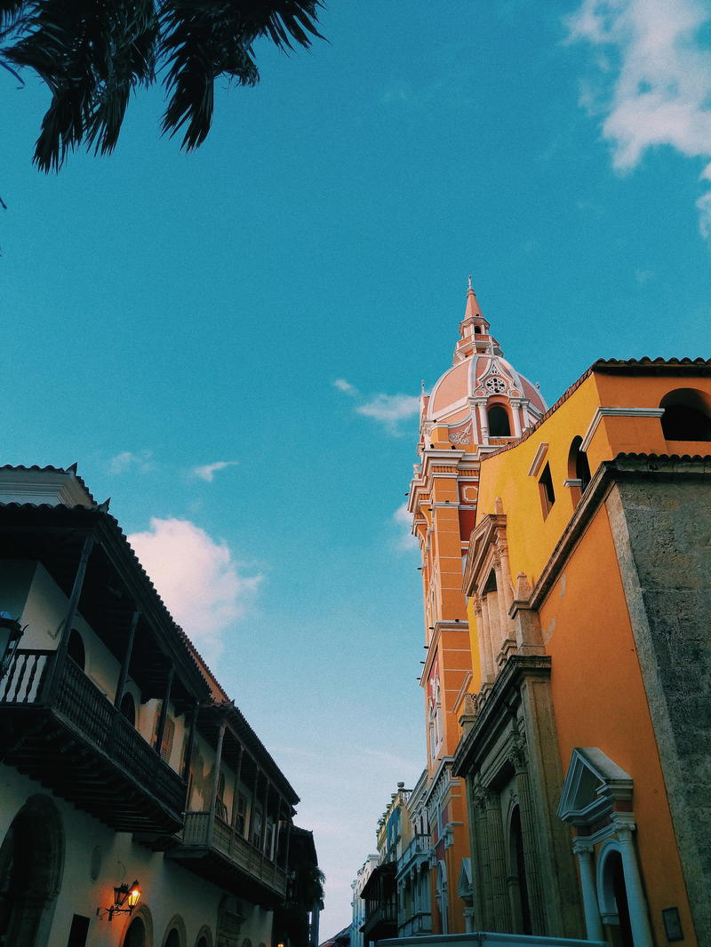 A yellow building with a clock tower in the background.