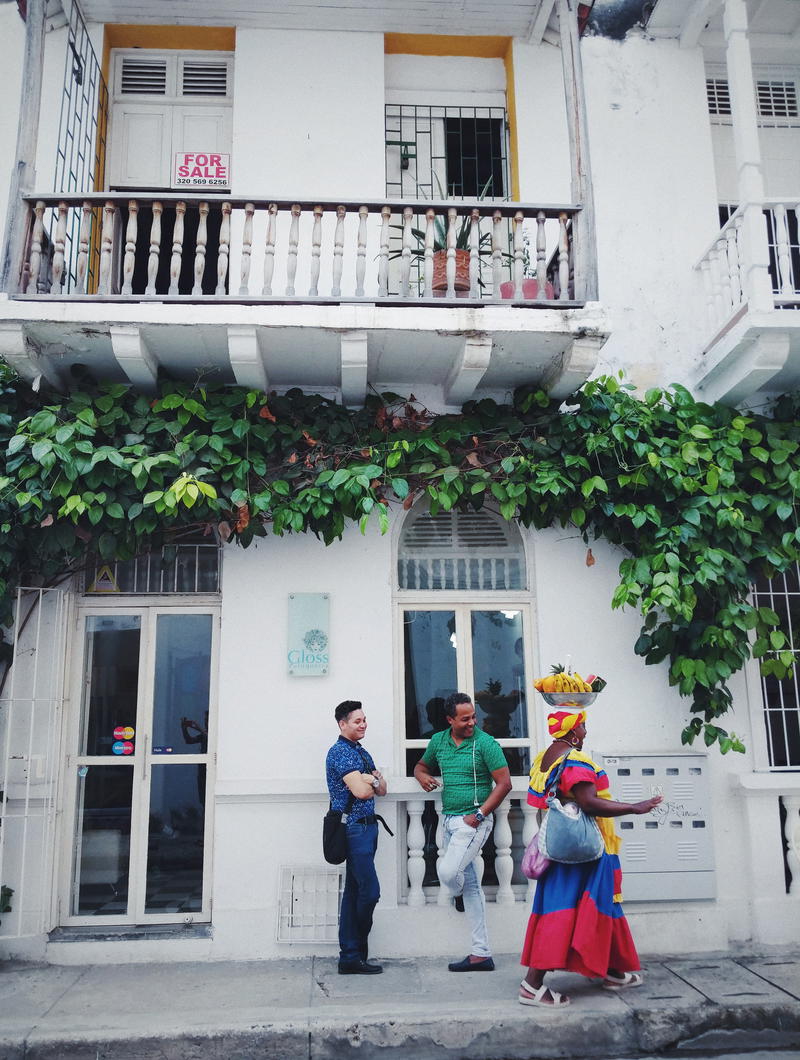 A group of people standing on the front porch of a building.