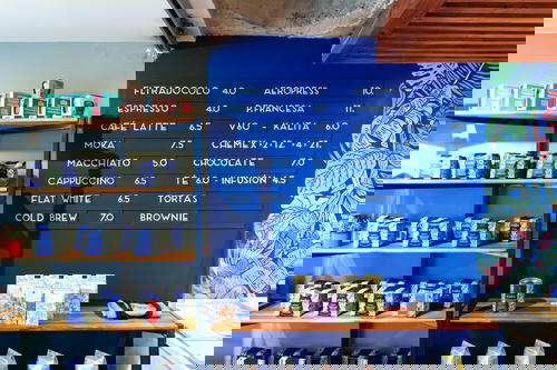 A coffee shop with a blue wall and shelves.