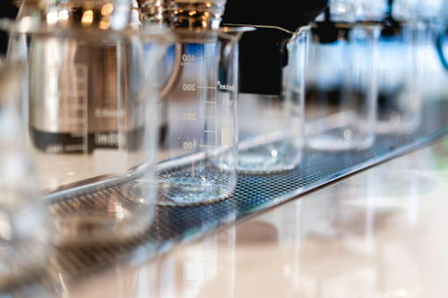 A line of glass beakers on a counter.