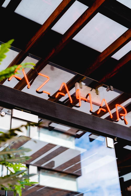 A restaurant with a neon sign that says azahar.