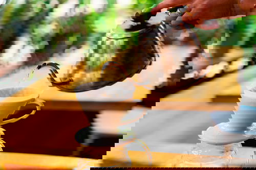 A person pouring coffee into a coffee pot.