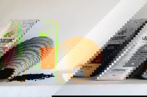 Two bags of coffee sitting on a shelf.