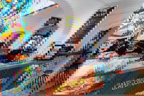 A cafe with a colorful mural on the wall.