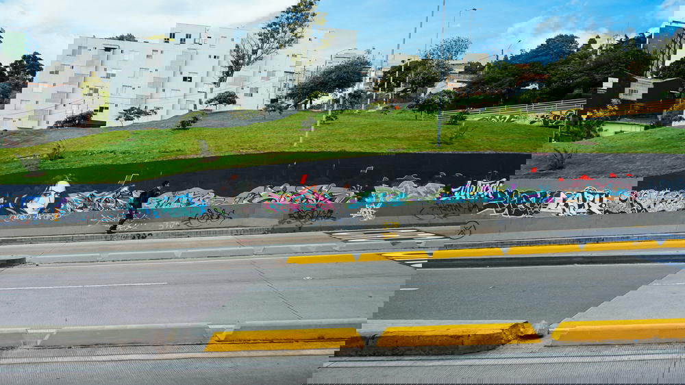 A person riding a skateboard near a graffiti covered wall.
