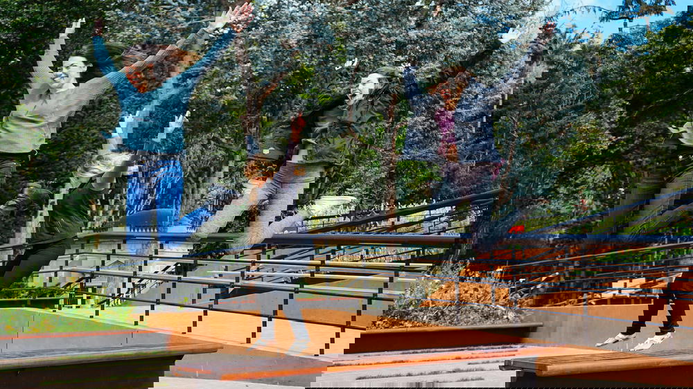 Three women jumping in the air in a park.