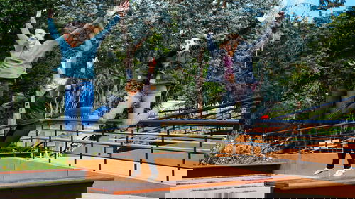 Three women jumping in the air in a park.