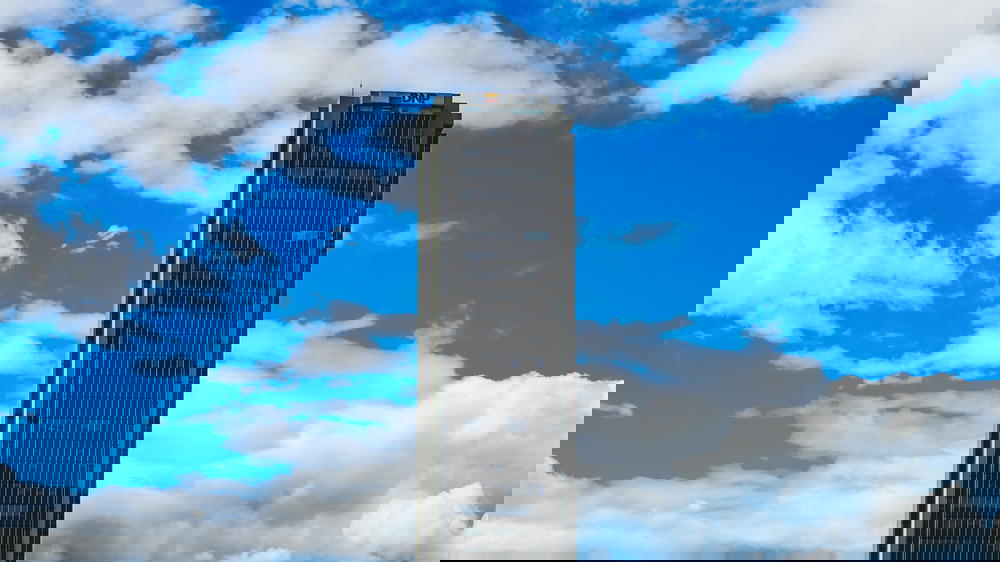 A tall building with a clock tower in the background.