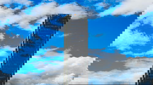 A tall building with a clock tower in the background.