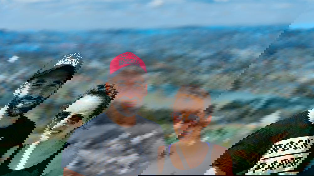 A man and woman posing for a photo on top of a mountain.