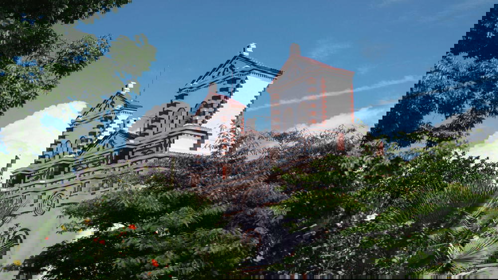 A white and red church with two towers.