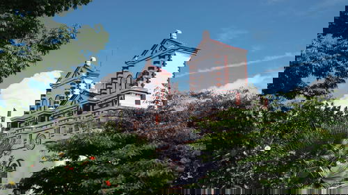 A white and red church with two towers.