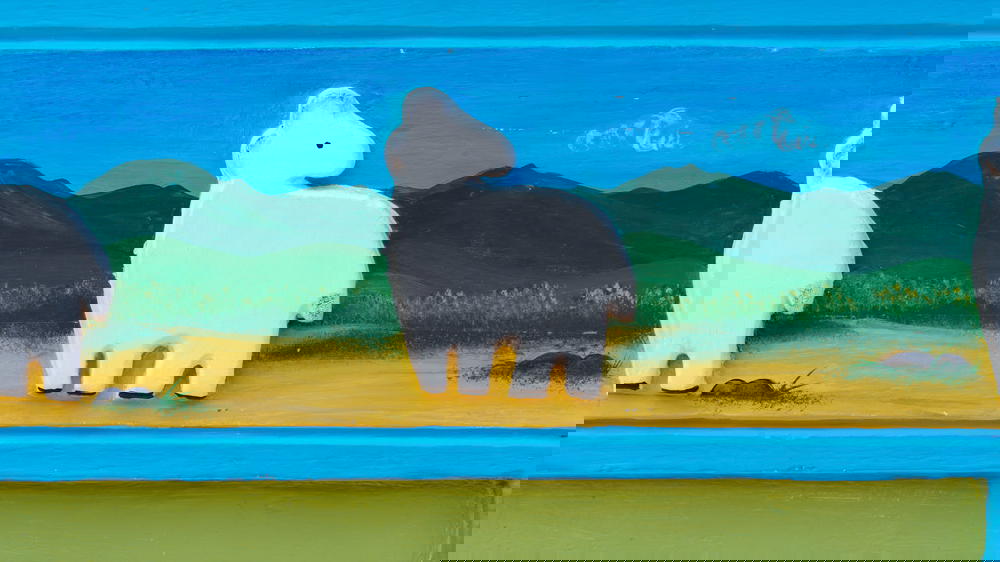 A group of llamas painted on a wall.