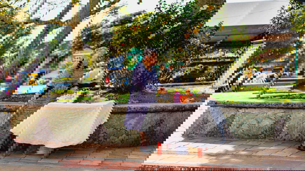 A woman in a dress standing in front of a table.