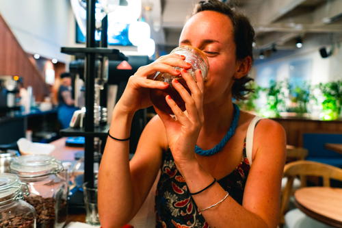 Girl happily drinking cold brew at Pergamino Cafe in Medellin, Colombia