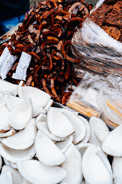 A pile of fried coconut sitting on top of a cart