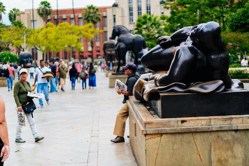 A group of people standing around a statue of a dog