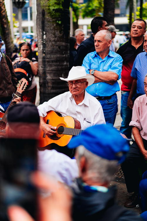 A man playing a guitar in a crowd of people