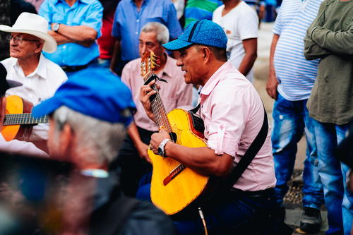 A man playing a guitar in front of a group of people
