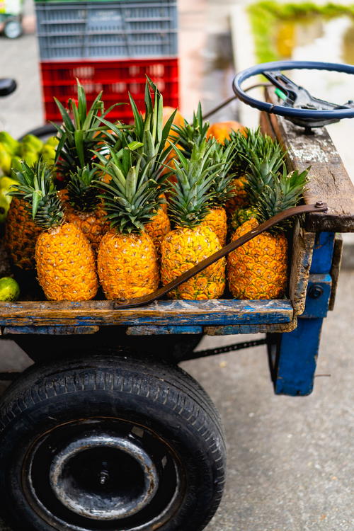 A cart full of pineapples on a street