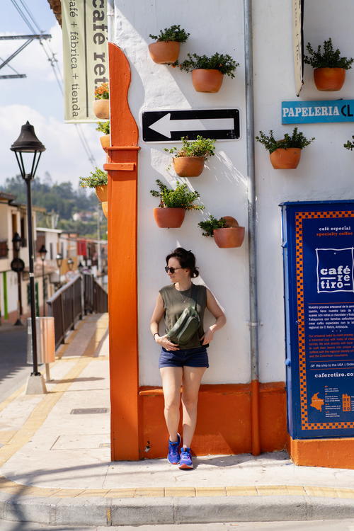 A woman standing in front of a building with potted plants on it