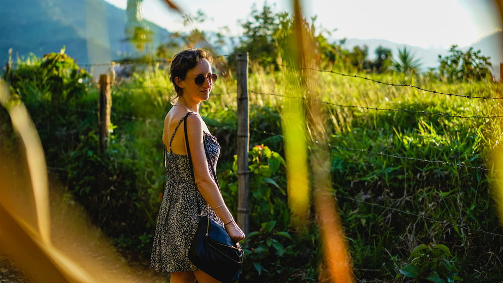 A woman in a dress holding a black purse