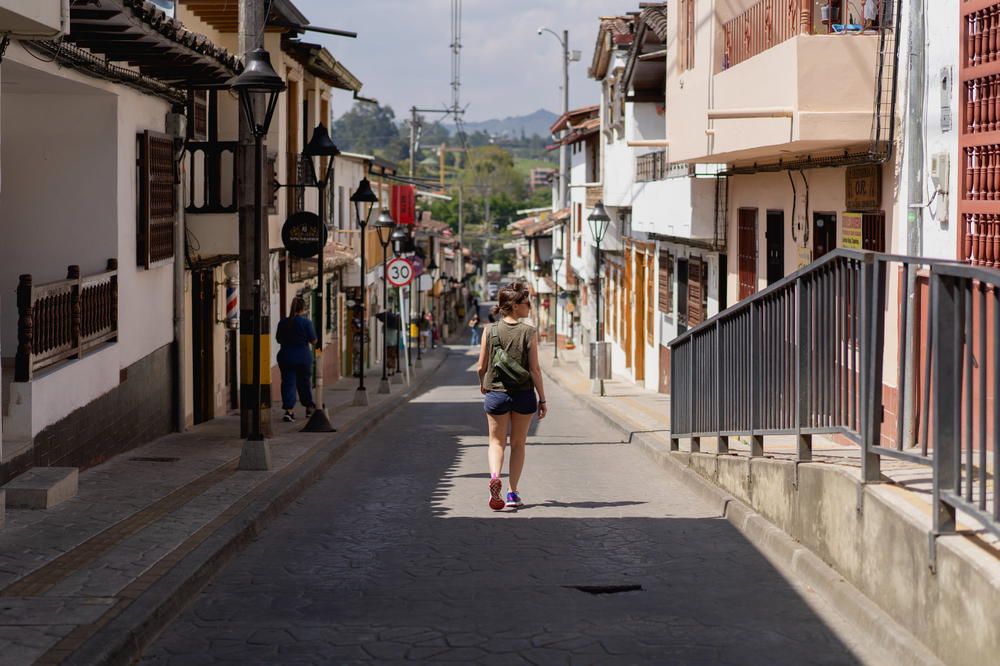 A woman walking down a street in El Retiro