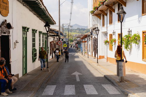 A group of people walking down a street next to tall buildings