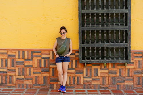 A woman standing in front of a yellow wall